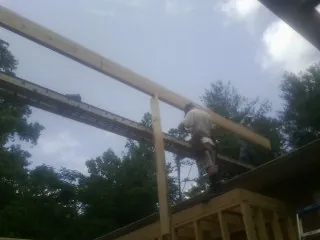 Carpenter setting a ridge beam over a new addition frame — Ice Dam Removal by Roofing Brothers in Agawam