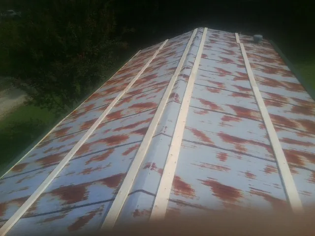 Rusted metal roof panels with new wood purlins before replacement — Storm Damage Roof Repair in Agawam by Roofing Brothers