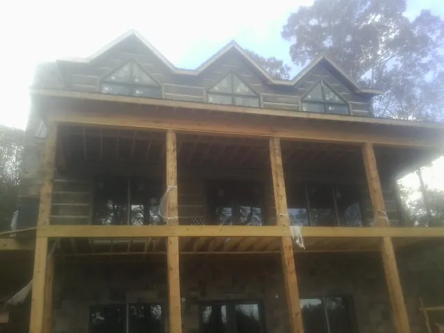 Dormers and porch framing on a large log home under construction — Roof Coating work by our crew in Agawam