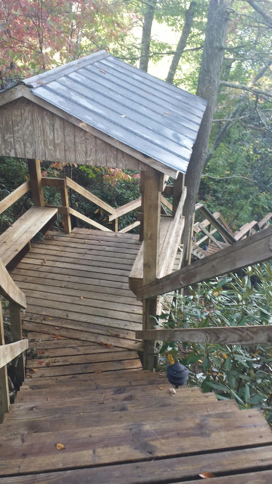 Metal roofed shelter over wooden steps on a wooded walkway — Skylight Repair & Installation work by our crew in Agawam